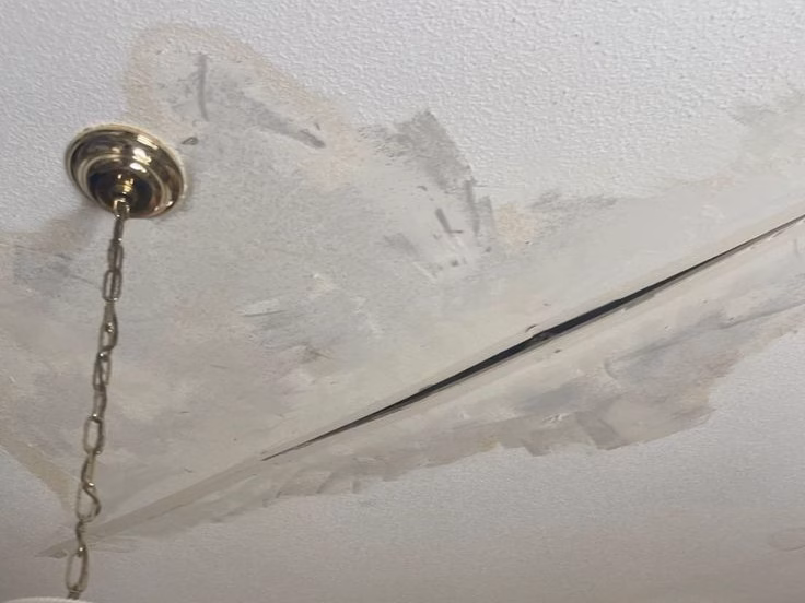 Identifying water stains in an attic during a roof leak inspection.